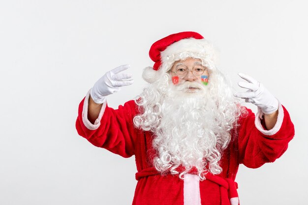 Vista frontal de santa claus con pintura de bandera azerbaiyana en su rostro en la pared blanca