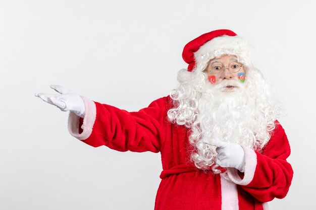 Vista frontal de santa claus con pinturas de la bandera turca y azerbaiyana en su rostro confundido en la pared blanca