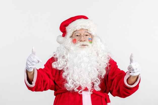 Vista frontal de santa claus con pinturas de la bandera turca y azerbaiyana en su rostro en la pared blanca