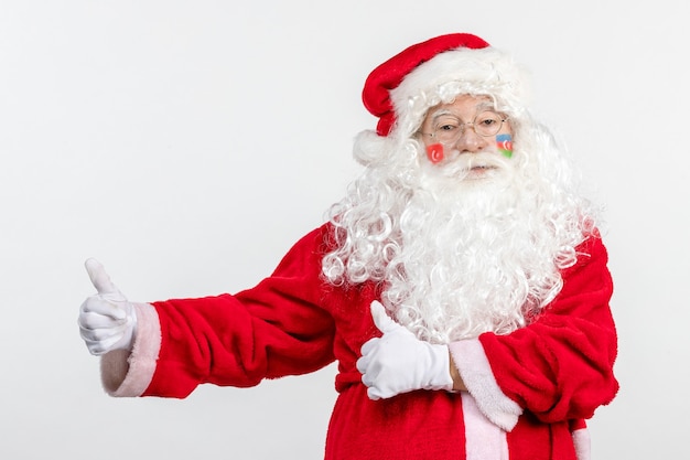 Vista frontal de santa claus con pinturas de la bandera turca y azerbaiyana en su rostro en la pared blanca