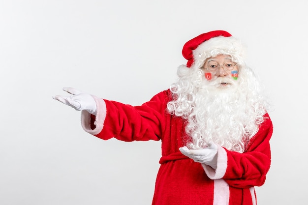 Vista frontal de santa claus con pinturas de la bandera turca y azerbaiyana en su rostro en la pared blanca