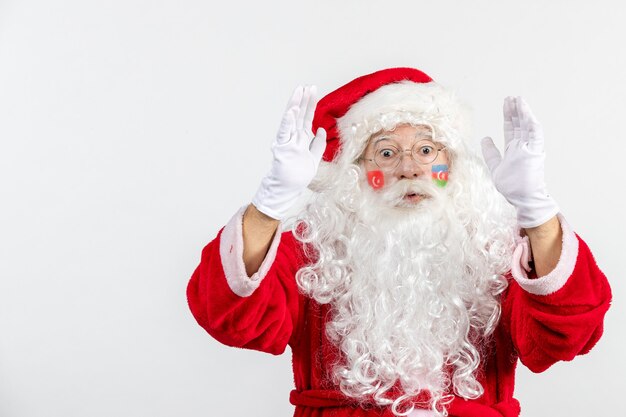 Vista frontal de santa claus con pinturas de la bandera turca y azerbaiyana en su rostro en la pared blanca