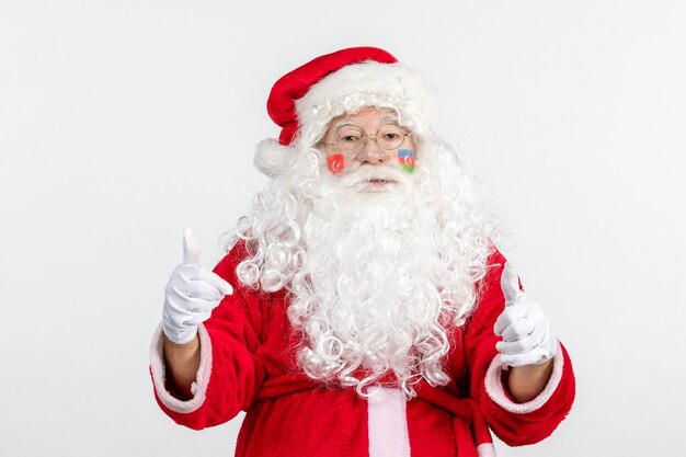 Vista frontal de santa claus con pinturas de la bandera turca y azerbaiyana en su rostro en la pared blanca