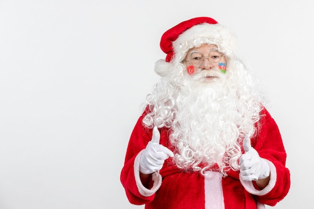 Vista frontal de santa claus con pinturas de la bandera turca y azerbaiyana en su rostro en la pared blanca