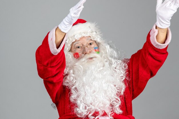 Vista frontal de santa claus con pinturas de la bandera turca y azerbaiyana en su rostro en la pared gris