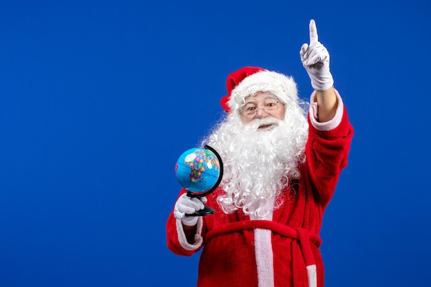 Vista frontal de santa claus sosteniendo un pequeño globo terráqueo en colores azules vacaciones de navidad año nuevo