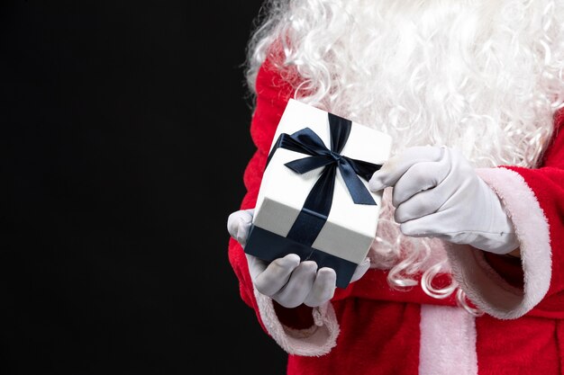 Vista frontal de santa claus en traje rojo clásico con presente