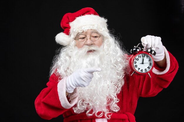 Vista frontal de santa claus en traje rojo clásico con relojes