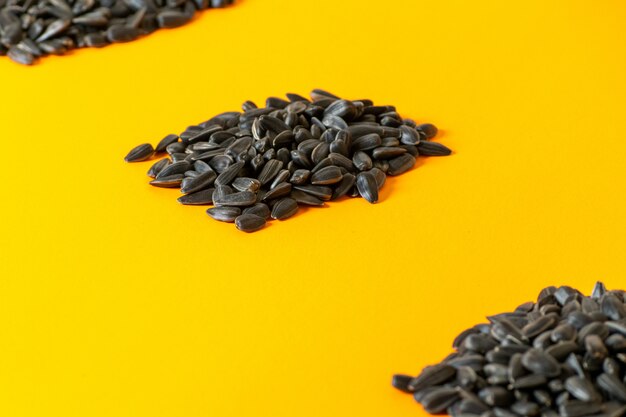 Una vista frontal de las semillas de girasol negras y fritas forradas en amarillo