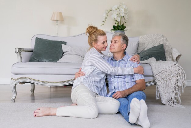 Vista frontal senior hombre y mujer sentada en el piso