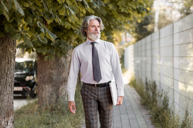 Vista frontal senior masculino caminando al aire libre