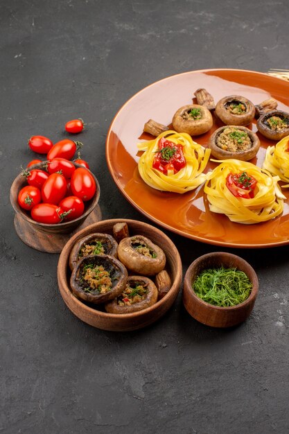 Vista frontal de setas cocidas con pasta de masa en el color de la cena de comida de plato de comida de mesa oscura