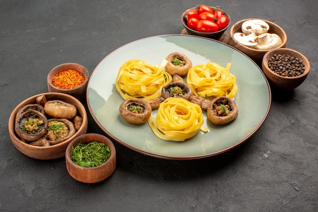 Vista frontal de setas cocidas con pasta de masa en la mesa oscura, comida de cena de color de alimentos