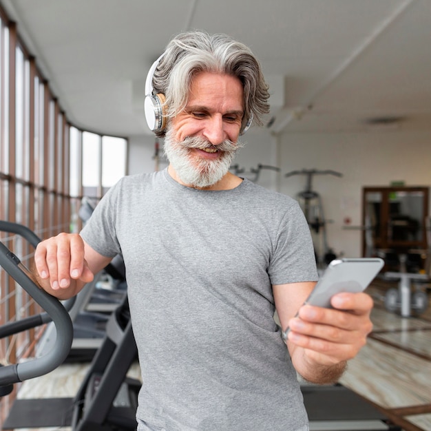 Vista frontal con smartphone en el gimnasio