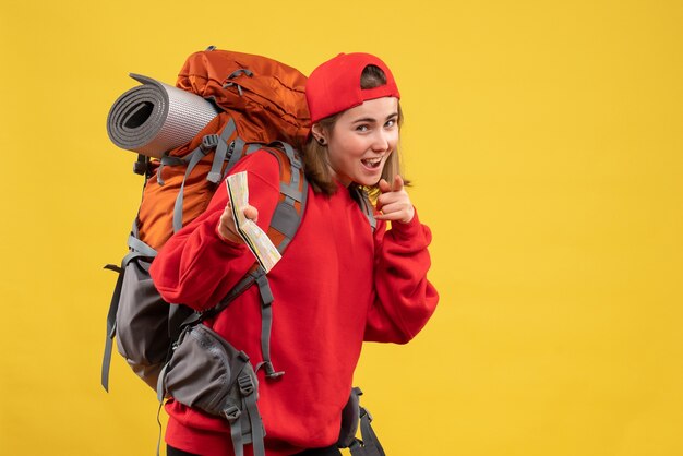 Vista frontal sonriente excursionista mujer con mochila grande con mapa