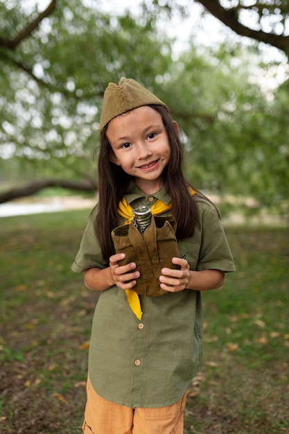 Vista frontal sonriente girl scout en la naturaleza