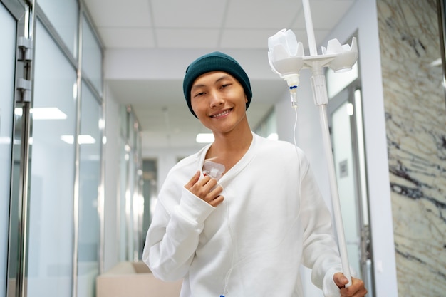 Vista frontal sonriente hombre asiático con cáncer