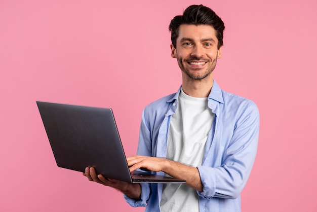 Vista frontal, de, sonriente, hombre, tenencia, computadora portátil