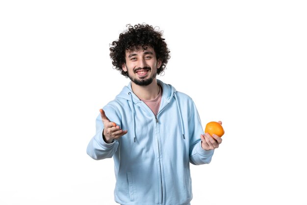 Vista frontal sonriente joven con naranja fresca sobre blanco
