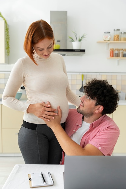 Foto gratuita vista frontal sonriente mujer embarazada en casa