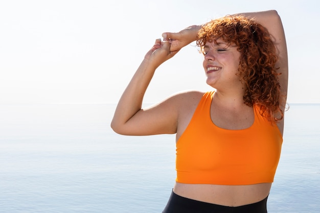 Foto gratuita vista frontal sonriente mujer estirando