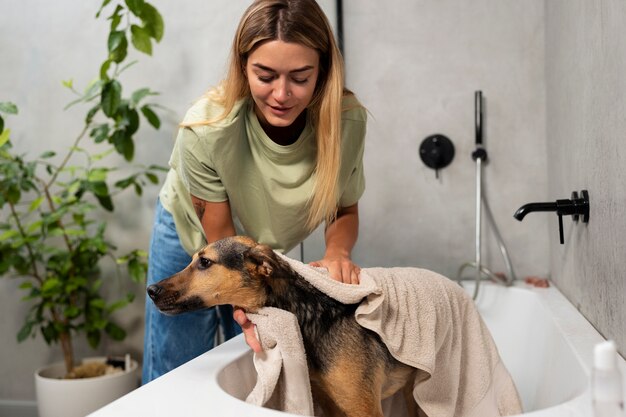 Vista frontal sonriente mujer lavando perro