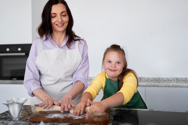 Vista frontal sonriente mujer y niña cocinando