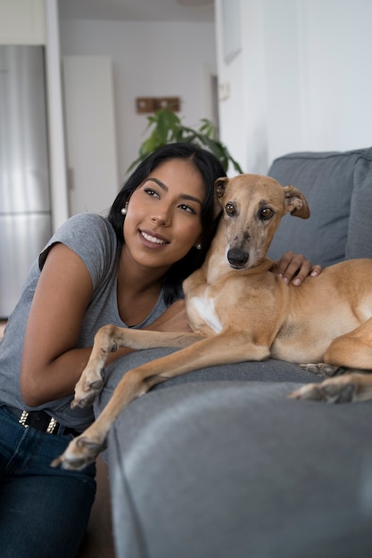 Vista frontal sonriente mujer y perro en casa