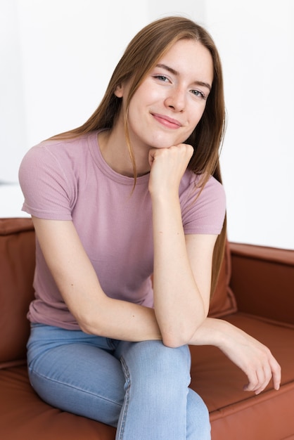 Vista frontal sonriente mujer sentada en el sofá