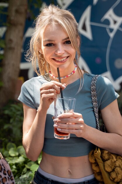 Vista frontal sonriente mujer sosteniendo bebida