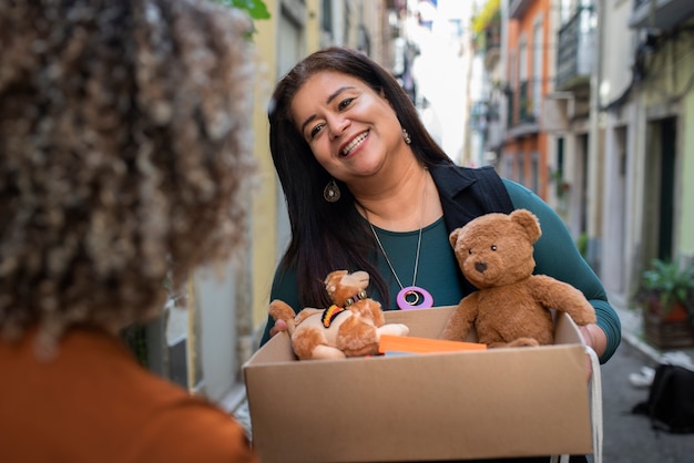 Vista frontal sonriente mujer sosteniendo caja