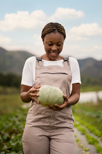 Vista frontal sonriente mujer sosteniendo calabaza