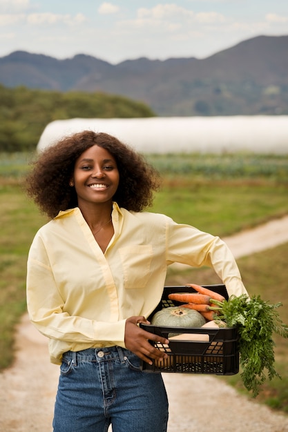 Vista frontal sonriente mujer sosteniendo cosecha