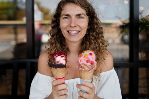 Foto gratuita vista frontal sonriente mujer sosteniendo dos helados