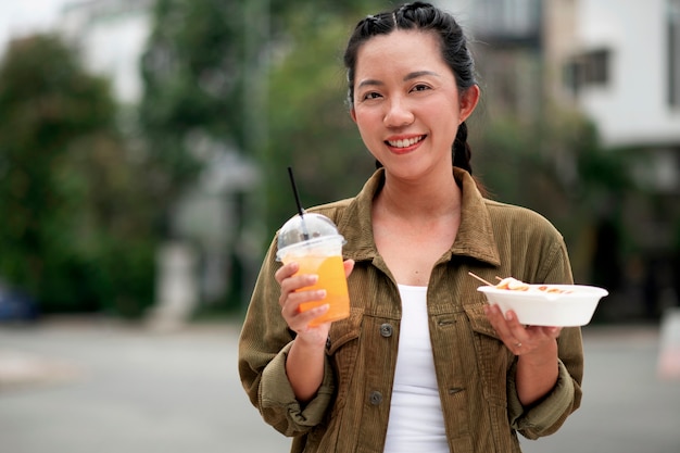 Foto gratuita vista frontal sonriente mujer sosteniendo refresco