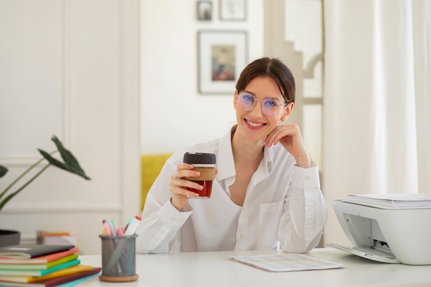 Vista frontal sonriente mujer sosteniendo taza de café