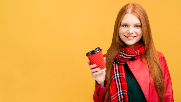 Vista frontal sonriente mujer sosteniendo la taza