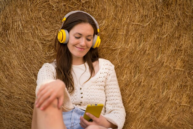 Vista frontal sonriente mujer sosteniendo teléfono inteligente