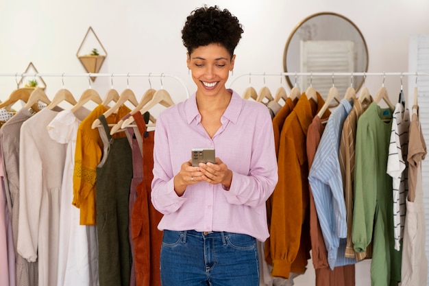 Foto gratuita vista frontal sonriente mujer sosteniendo teléfono inteligente