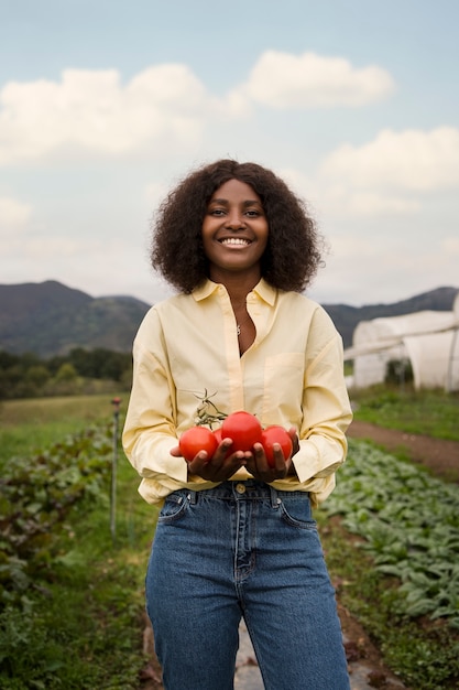 Foto gratuita vista frontal sonriente mujer sosteniendo tomates