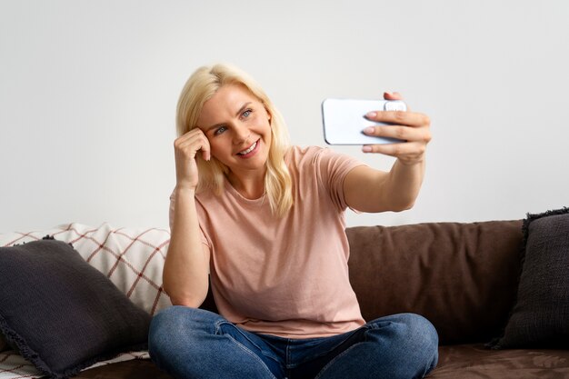 Vista frontal sonriente mujer tomando selfie