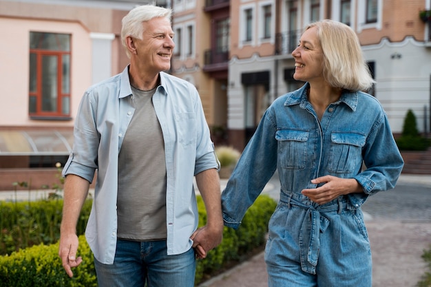 Vista frontal de la sonriente pareja de ancianos en la ciudad