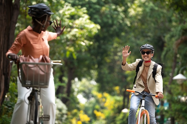 Vista frontal sonrientes colegas en bicicleta