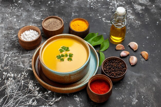 Vista frontal de la sopa de calabaza con condimentos en una mesa oscura cena suave de acción de gracias