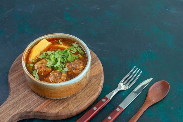 Vista frontal de la sopa de carne con albóndigas verdes y patatas en rodajas en el plato de verduras de salsa de sopa de comida de escritorio azul oscuro