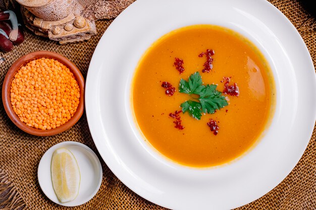 Vista frontal sopa de lentejas con una rodaja de limón