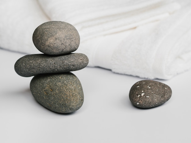 Foto gratuita vista frontal del spa con piedras junto a las toallas.
