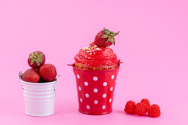 Una vista frontal de la tarta de fresa dentro de la canasta junto con fresas rojas frescas en el escritorio rosa