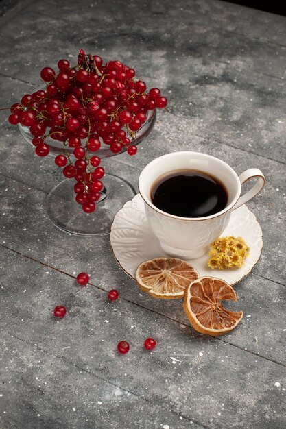 Vista frontal de la taza de café con arándanos rojos frescos en el escritorio gris café baya fruta