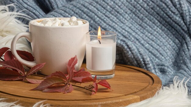 Vista frontal de la taza de chocolate caliente con malvaviscos y velas